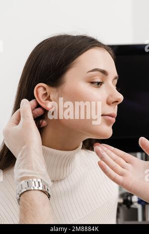 L'otoplastie est un remodelage chirurgical de la pinna ou de l'oreille externe pour corriger une irrégularité et améliorer l'apparence. Le médecin chirurgien examine l'oreille de fille b Banque D'Images