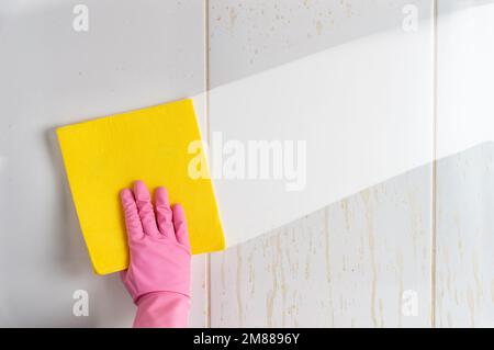 Vue en grand angle de la personne portant des gants de nettoyage du sol dans la cuisine Banque D'Images