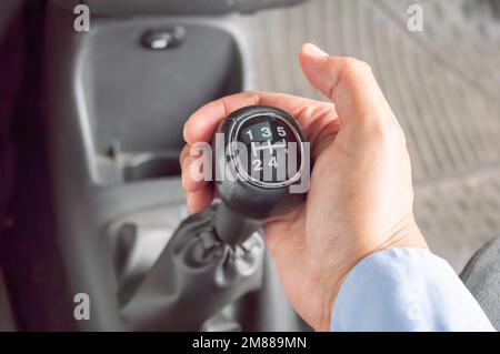 Plan court d'un homme d'affaires changeant les rapports d'une voiture.main tenant la boîte de vitesses manuelle dans la voiture. Banque D'Images