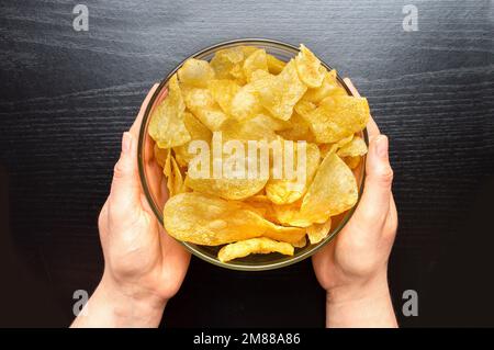 Vue de dessus prise de vue d'un bol de pommes de terre frites sur fond noir. Concept d'en-cas. Banque D'Images