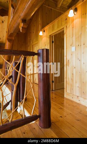 Balustrades en branches de cèdre et planchers en bois de pin rouge à l'étage à l'intérieur de la maison en rondins de style scandinave. Banque D'Images