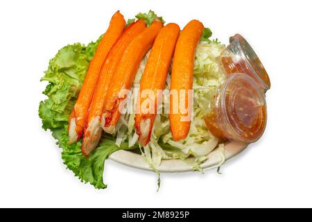 Découper des bâtonnets de crabe frits avec de la sauce trempée et mélanger les légumes sur du blanc isolé. Banque D'Images