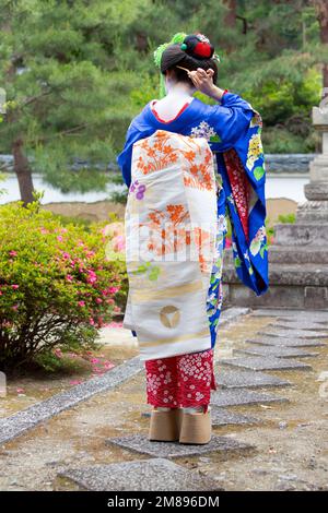 Une Geisha et maiko tirer sur Manpakuji, Kyoto Temple Banque D'Images