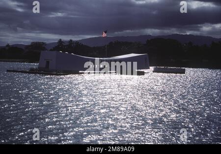 Le drapeau américain survole le Mémorial USS ARIZONA (BB-39) tandis que le soleil met en valeur les eaux environnantes. Base: Pearl Harbor État: Hawaï (HI) pays: Etats-Unis d'Amérique (USA) Banque D'Images