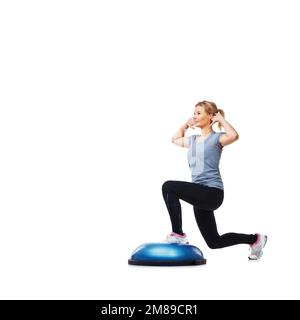 Elle suit un plan de forme physique strict. Une jeune femme attirante lapira ses cuisses sur un bosu-ball. Banque D'Images