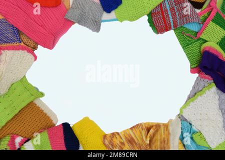 Vue de dessus d'un montage d'objets en laine tricotés colorés faits à la main, en forme d'ovale sur fond blanc Banque D'Images