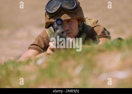 Visez vous. Un jeune soldat visant avec son fusil en étant allongé sur le sol. Banque D'Images