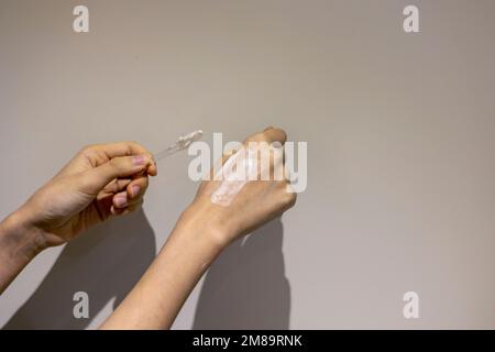 Application de crème cosmétique sur les mains avec une spatule Banque D'Images