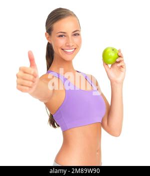 Femme, pomme et pouces en studio portrait pour la santé, la nutrition ou le bien-être par fond blanc. Modèle isolé, fruits sains ou sourire pour l'alimentation Banque D'Images