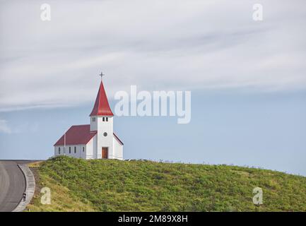 Église au toit rouge sur fond bleu pâle Banque D'Images