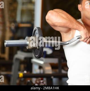 Beau homme à la salle de gym faisant des exercices. Beau sportif homme à la salle de gym faisant des exercices. Banque D'Images