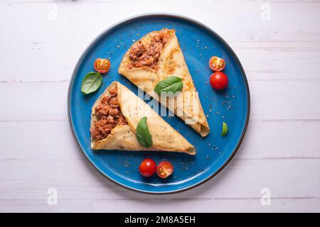 Crêpes à la viande bolognaise. Les crêpes sont une recette d'origine française dans laquelle est préparée une pâte à base de farine, d'œufs, de lait, de beurre et de sel. Banque D'Images