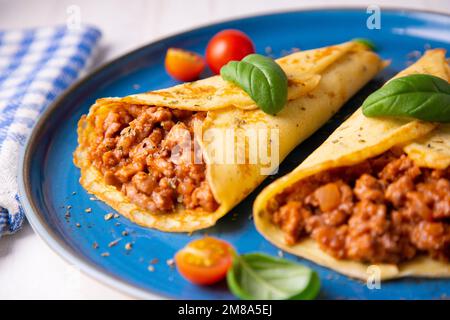 Crêpes à la viande bolognaise. Les crêpes sont une recette d'origine française dans laquelle est préparée une pâte à base de farine, d'œufs, de lait, de beurre et de sel. Banque D'Images