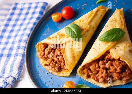 Crêpes à la viande bolognaise. Les crêpes sont une recette d'origine française dans laquelle est préparée une pâte à base de farine, d'œufs, de lait, de beurre et de sel. Banque D'Images