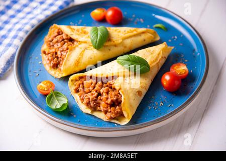 Crêpes à la viande bolognaise. Les crêpes sont une recette d'origine française dans laquelle est préparée une pâte à base de farine, d'œufs, de lait, de beurre et de sel. Banque D'Images