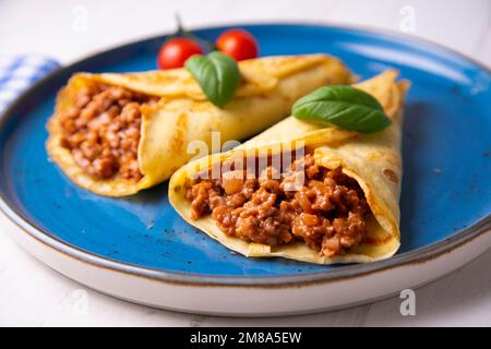 Crêpes à la viande bolognaise. Les crêpes sont une recette d'origine française dans laquelle est préparée une pâte à base de farine, d'œufs, de lait, de beurre et de sel. Banque D'Images