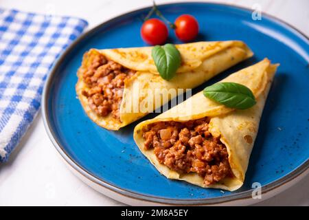 Crêpes à la viande bolognaise. Les crêpes sont une recette d'origine française dans laquelle est préparée une pâte à base de farine, d'œufs, de lait, de beurre et de sel. Banque D'Images