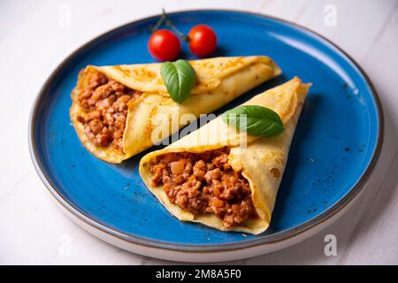 Crêpes à la viande bolognaise. Les crêpes sont une recette d'origine française dans laquelle est préparée une pâte à base de farine, d'œufs, de lait, de beurre et de sel. Banque D'Images