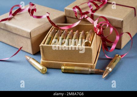 Cartouches de fusil dans une boîte cadeau. 223 cartouches ammo de calibre et trois boîtes en carton cadeau. Vue en gros plan Banque D'Images