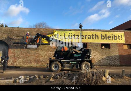 Erkelenz, Allemagne. 13th janvier 2023. Les travailleurs retirent une bannière 'Lützerath bleibt!' d'un mur. La société d'énergie RWE veut fouiller le charbon situé sous Lützerath - à cette fin, le hameau sur le territoire de la ville d'Erkelenz à la mine de lignite opencast Garzweiler II doit être démoli. Credit: Petra Albers/dpa/Alay Live News Banque D'Images