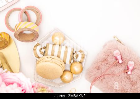 Bureau féminin avec oreillettes dorées et roses, sac à main et friandises Banque D'Images