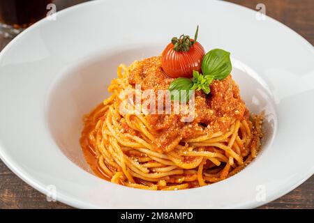 Pâtes avec fromage et sauce tomate sur une assiette en porcelaine blanche Banque D'Images
