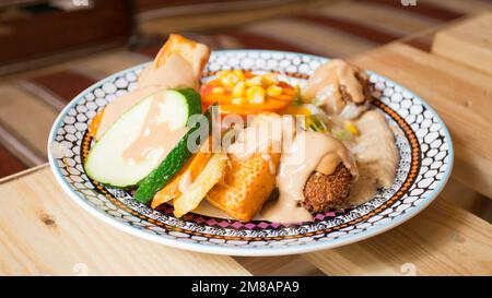 Plat combiné de falafel avec légumes. Faláfel ou falafel​ est une croquette de pois chiches ou de fèves. Il est généralement consommé au Moyen-Orient. Banque D'Images