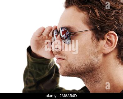 Prêt à tout. Gros plan d'un beau jeune soldat tenant ses lunettes de soleil. Banque D'Images