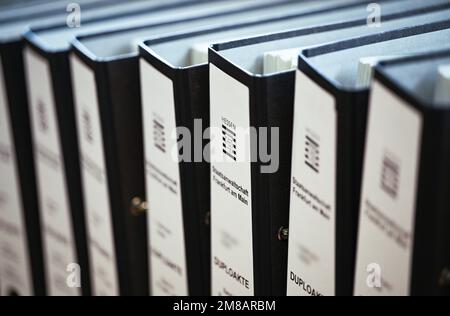 13 janvier 2023, Hessen, Francfort-sur-le-main: Dossiers d'enquête du bureau du procureur général stand au début du procès contre un ancien procureur général à Francfort dans la salle d'audience du tribunal régional. L'avocat suspendu avait dirigé un bureau central national de lutte contre les crimes contre la propriété et la corruption dans le secteur de la santé au Bureau du Procureur général de Francfort. Il doit maintenant être jugé pour suspicion de corruption. Photo: Arne Dedert/dpa/POOL/dpa - ATTENTION: Les données personnelles ont été pixélisées pour des raisons juridiques Banque D'Images