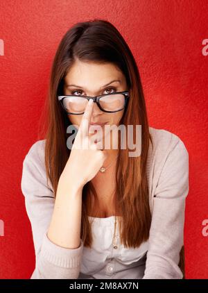 C'est une femme intelligente. Portrait court d'une jolie jeune femme poussant ses lunettes sur son nez. Banque D'Images