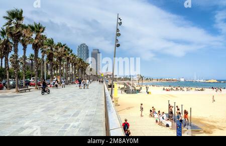 Barcelone, Espagne - 6 juillet 2017: Vue de jour des touristes marchant par Passeig Maritim en face de la plage de Barceloneta et des gratte-ciels à Barcelone, Espagne. Banque D'Images