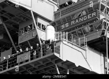 Les membres de l'équipage brandisent les rails à côté de l'île du porte-avions USS RANGER (CV 61) alors que le navire part dans un déploiement dans le Pacifique occidental. Base: Naval Air Station, North Island État: Californie (CA) pays: Etats-Unis d'Amérique (USA) Banque D'Images