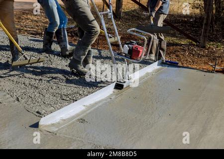 La machine est utilisée dans la construction d'une nouvelle allée pour aligner une nouvelle couche de béton sur la couche compactée supérieure Banque D'Images