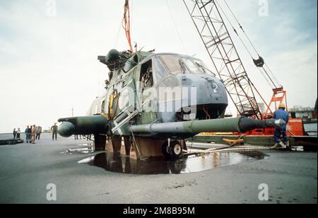 Des flaques se forment à l'hélicoptère Jolly Green Giant HH-3E de la Force aérienne, qui s'écoule sur des blocs de la jetée des activités de la flotte militaire. L'hélicoptère, qui s'est écrasé à 5,6 milles au large de la côte d'Okinawa pendant une mission d'entraînement de nuit, a été récupéré b. base: Naha État: Okinawa pays: Japon (JPN) Banque D'Images