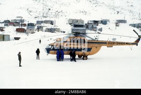 Les dignitaires soviétiques et les membres de la presse soviétique se préparent à partir de la région à bord d'un hélicoptère mi-8 Hip de Mil à la suite d'une cérémonie célébrant l'arrivée de l'expédition conjointe du pont de Béring américano-soviétique. Organisée pour promouvoir de meilleures relations entre les États-Unis et l'URSS, l'expédition a encouragé les autochtones de l'Alaska à rendre visite à des parents en Union soviétique. Les membres de l'équipe ont parcouru 800 kilomètres à travers l'Union soviétique jusqu'à la ligne de date internationale, puis ont continué jusqu'à Little Diomede. Base: Little Diomede État: Alaska (AK) pays: Etats-Unis d'Amérique (USA) Banque D'Images