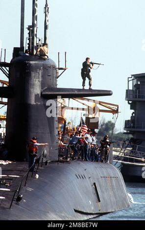 Un membre du Marine Detachment Security Group 6, qui fait partie d'une équipe de sécurité anti-terroriste de la flotte, prend sa carabine à bord du sous-marin de missiles stratégiques à propulsion nucléaire USS CASIMIR PULASKI (SSBN-633) pour signaler l'emplacement d'un intrus « terroriste » lors de l'exercice LantCoopEx 1-89. Une autre Marine est prête à tirer de la coque du sous-marin. Objet opération/série: LANTCOOPEX 1-89 base: Port Canaveral État: Floride (FL) pays: États-Unis d'Amérique (USA) Banque D'Images