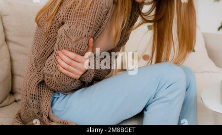 Gros plan des mains de femme tenant le ventre par côté une fille méconnaissable femme avec ordinateur portable travaillant se sent de mauvais problèmes digestifs douleur abdominale douloureuse Banque D'Images