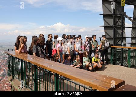 Groupe de jeunes (peut-être une classe scolaire?) Poser pour une photo sur une plate-forme panoramique (au sommet du mont Tampa en Roumanie, à côté du panneau Brașov) Banque D'Images