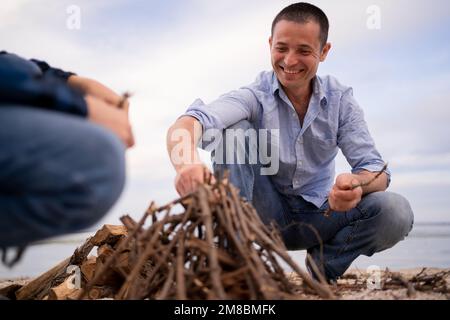 Père et fils passant du temps heureux de loisirs ensemble en plein air dans le camp. Famille homme enfant faisant feu de camp sur les bois de la nature. Relations bonheur activi Banque D'Images