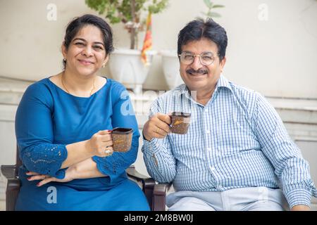 Un couple indien mûr heureux prenant le thé du matin ou le café ensemble. Vie domestique ou de retraite. Banque D'Images