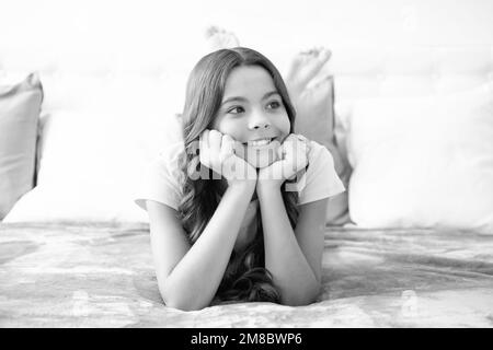 Enfant rêvant, rêvant. Adolescent fille de repos dans le lit à la chambre à la maison. Enfant se détendant à l'intérieur de la chambre. Banque D'Images