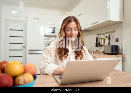 Jeune femme heureuse travaillant sur un ordinateur portable Banque D'Images