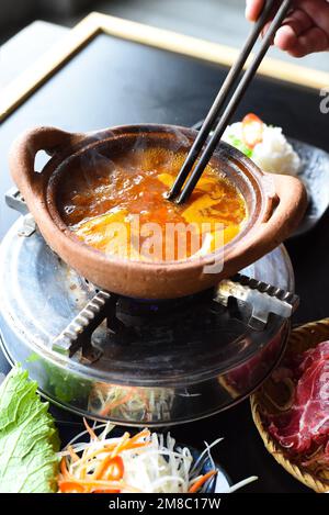 Plat traditionnel coréen en pot avec bœuf et bouillon épicé sur table noire Banque D'Images