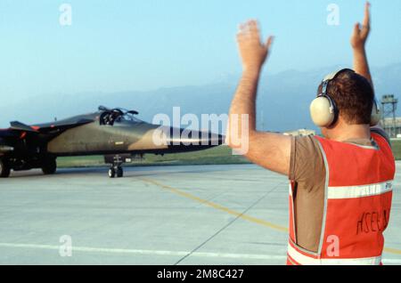 Un membre de l'unité de maintenance des aéronefs de 42nd signale au pilote d'un avion F-111E du Fighter Squadron tactique 55th qui roule en position de lancement aux États-Unis Forces aériennes en Europe (USAFE) exercice Afficher détermination '89. Objet opération/série: AFFICHER LA DÉTERMINATION '89 base: Aviano Air base État: Pordenone pays: Italie (ITA) Banque D'Images