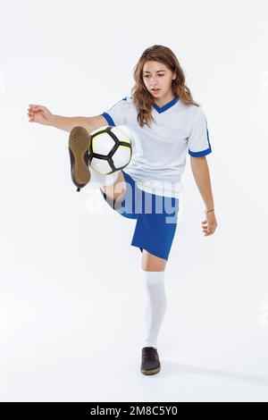 Une fille européenne de joueur de football avec un ballon de football sur fond blanc Banque D'Images