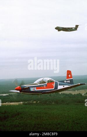 Vue aérienne avant gauche d'un avion Pilatus PC-9 à bord d'un vol hors de la base aérienne de Pope, en Caroline du Nord. L'avion fabriqué en Suisse est évalué par un américain Carte d'essai de l'armée. Un avion C-5A Galaxy est en arrière-plan. État: Caroline du Nord (NC) pays: Etats-Unis d'Amérique (USA) Banque D'Images