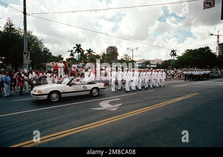 Alors qu'ils passent devant le stand de révision lors de la parade commémorative du général Lewis Walt, des membres de équipage du sous-marin d'attaque nucléaire USS ALBUQUERQUE (SSN 706) marchent derrière une automobile dans laquelle leur commandant pilote. Le défilé fait partie des activités qui ont lieu durant la semaine d'appréciation de la Marine 1989, parrainée par l'autorité de Port Everglades, la communauté du comté de Broward et la Ligue navale des États-Unis. Base: Fort Lauderdale État: Floride (FL) pays: États-Unis d'Amérique (USA) Banque D'Images