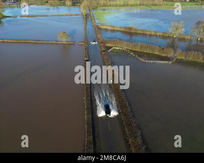 Sutton St Nicholas, Herefordshire, Royaume-Uni – Vendredi 13th janvier 2023 – Météo au Royaume-Uni – vue aérienne des véhicules qui traversent les eaux de crue depuis la rivière Lugg voisine, sur une route rurale entre Sutton St Nicholas et Hereford. Après des jours de précipitations, les rivières locales comme la rivière Lugg, la rivière Tée et la rivière Wye sont toutes à des niveaux très élevés. Plus de prévisions de pluie. Photo Steven May / Alamy Live News Banque D'Images