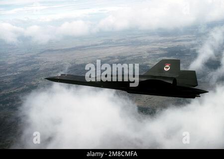 Vue aérienne vue de gauche d'un avion de reconnaissance SR-71 Blackbird de l'escadre stratégique de reconnaissance 9th, volant au-dessus de nuages épars, en mission hors de la base aérienne de Beale, en Californie. Date exacte prise de vue inconnue. Pays : inconnu Banque D'Images