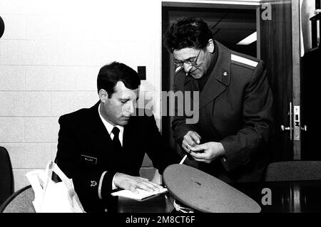 Membre d'un U.S. Le groupe de la Marine explique l'importance de divers rubans de la Marine à un membre d'une bande militaire soviétique lors de la visite des Soviétiques aux États-Unis École de musique de la Marine. Base: Base navale Amphib, Little Creek État: Virginie (va) pays: Etats-Unis d'Amérique (USA) Banque D'Images